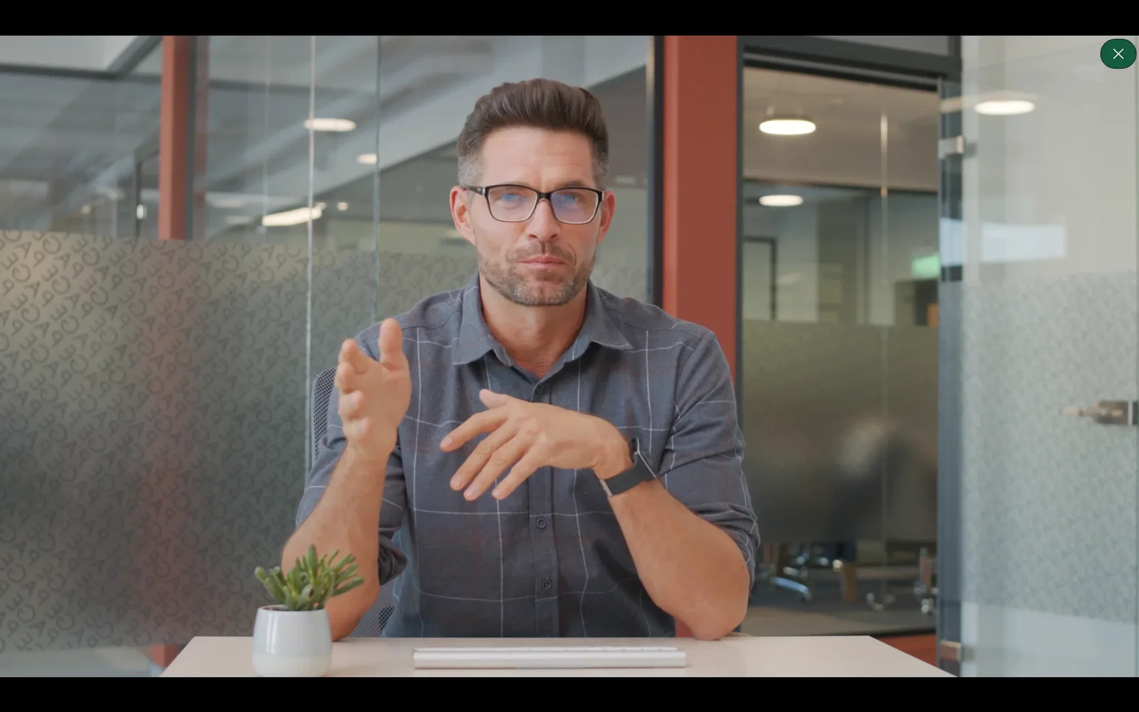 A customer testimonial clip playing over the main video, with a close button in the top right